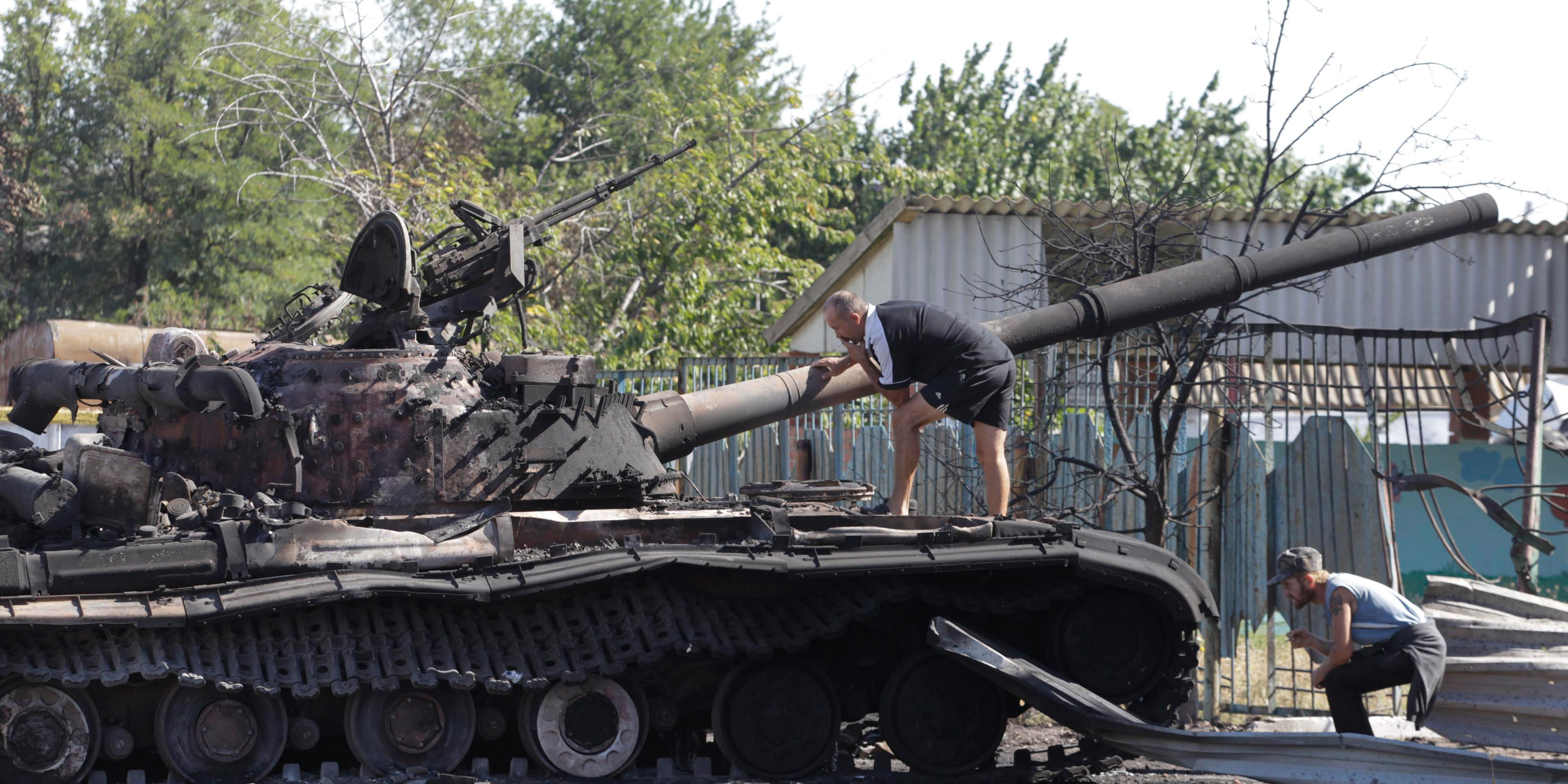 Men inspect a burnt out Ukrainian tank in the village of Kominternovo, on the outskirts of the southern coastal town of Mariupol, September 6. Photo: Reuters