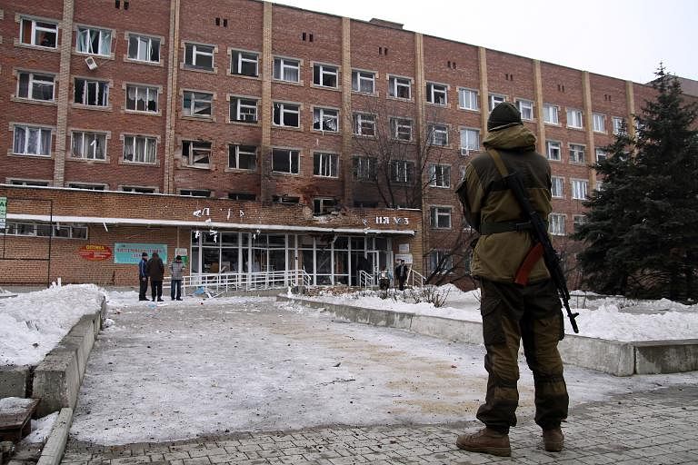 An armed man stands in front of a hospital destroyed after shelling between Ukrainian forces and pro-Russian separatists in the eastern Ukrainian city of Donetsk, on January 19. Photo: Reuters 