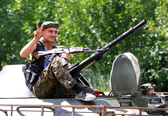A Ukrainian serviceman gestures while driving past onboard a military armoured vehicle in the eastern Ukrainian town of Kramatorsk, August 5, 2014. Photo: Reuters