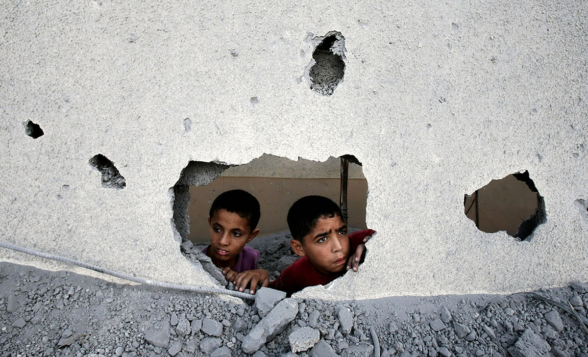 Palestinian children look through the ruin of Gaza prison building destroyed by Israel attacks in Gaza on July 15, 2014.  Photo: Getty Images