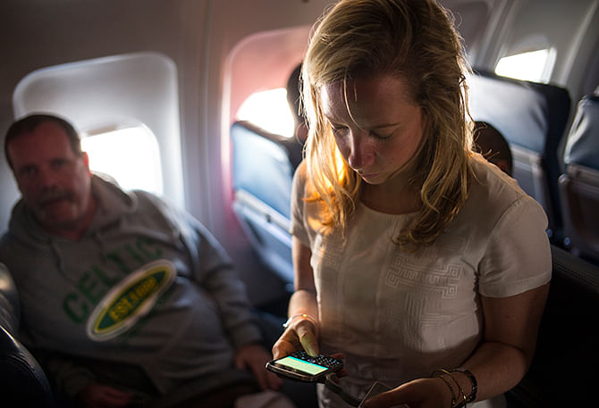 A Delta Air Line passenger uses her Blackberry as passengers wait to disembark June 6, 2014 after a flight from New York to Denver, Colorado. Photo: Getty Images