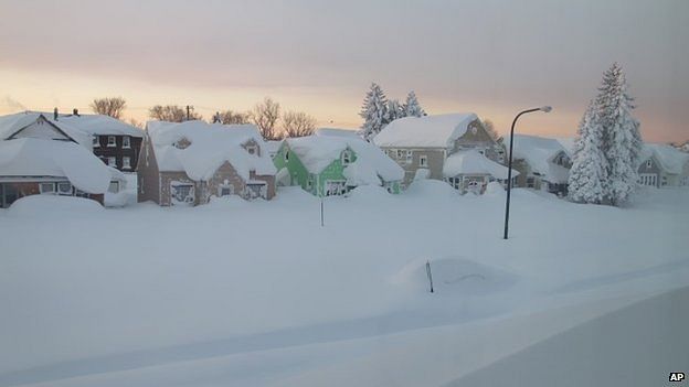 Snow covers a street at daybreak in Buffalo