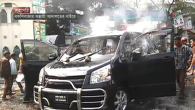 BNP men torch a private car near Dhaka Medical College and Hospital after they clash with police at Bakshibazar in Dhaka Wednesday. Photo: TV grab
