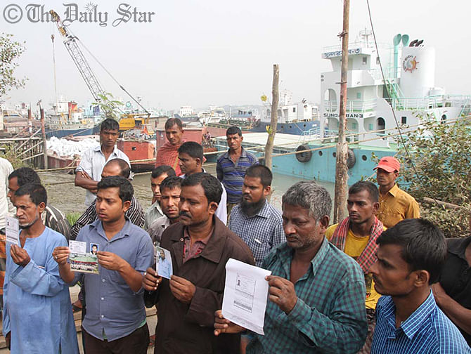 Relatives at Majhirghat in Chittagong hold the photos of their dear ones who went missing after FV Bandhan, a vessel of Bengal Fisheries Limited, capsized with 29 crewmen on board about 30 nautical miles northwest off the coast of Saint Martins’ Island when a Singapore-bound merchant vessel Bashundhara-8 hit it. Photo: Star