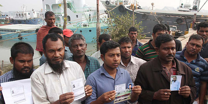 Relatives at Majhirghat in Chittagong hold the photos of their dear ones who went missing after FV Bandhan, a vessel of Bengal Fisheries Limited, capsized with 29 crewmen on board about 30 nautical miles northwest off the coast of Saint Martins’ Island when a Singapore-bound merchant vessel Bashundhara-8 hit it yesterday. Photo: Star