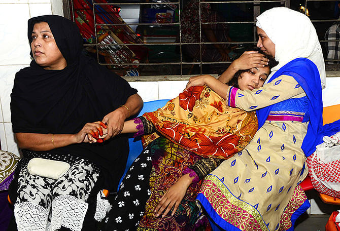 Relatives try to console Ratri, wife of deceased Simon, at Dhaka Medical College Hospital Thursday night. Simon and his father were shot near their Khilgaon home apparently by muggers. Photo: Courtesy