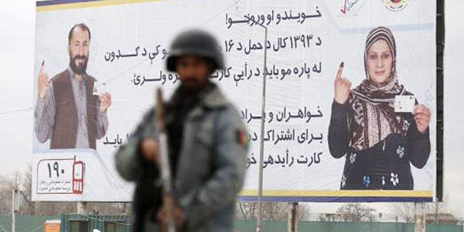 A policeman stands near a billboard for the presidential election at a checkpoint in Kabul, April 4, 2014, before Saturday's presidential election. Photo: Reuters