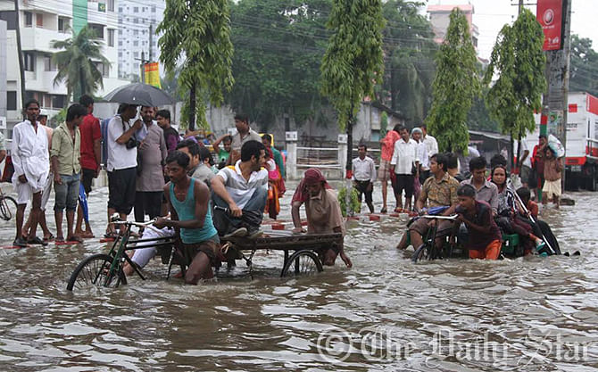 Pedestrians suffer much as water clogged on the road in Muradpur area of Chittagong on Friday. Photo: Anurup Kanti Das
