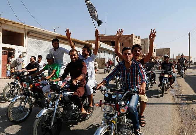 Residents of Tabqa city tour the streets on motorcycles, carrying flags in celebration after Tabqa air base fell to Islamic State militants, in nearby Raqqa city August 24, 2014. Photo: Reuters