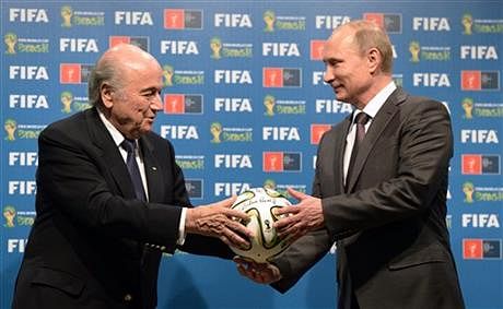 In this AP file photo taken on Sunday, July 13, 2014, FIFA President Sepp Blatter, left, and Russian President Vladimir Putin hold a soccer ball during the official ceremony of handover to Russia as the 2018 World Cup hosts, after the World Cup final soccer match between Germany and Argentina at the Maracana Stadium in Rio de Janeiro, Brazil. 