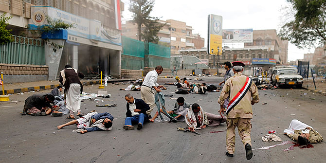 First responders check the wounded and the dead at the site of a suicide attack in Sanaa October 9, 2014. Photo: Reuters